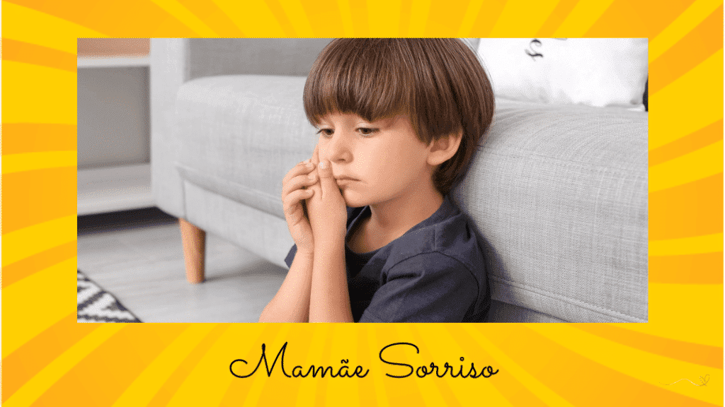 Main causes of toothache in children: boy sitting on the living room floor with his hand on his jaw due to toothache